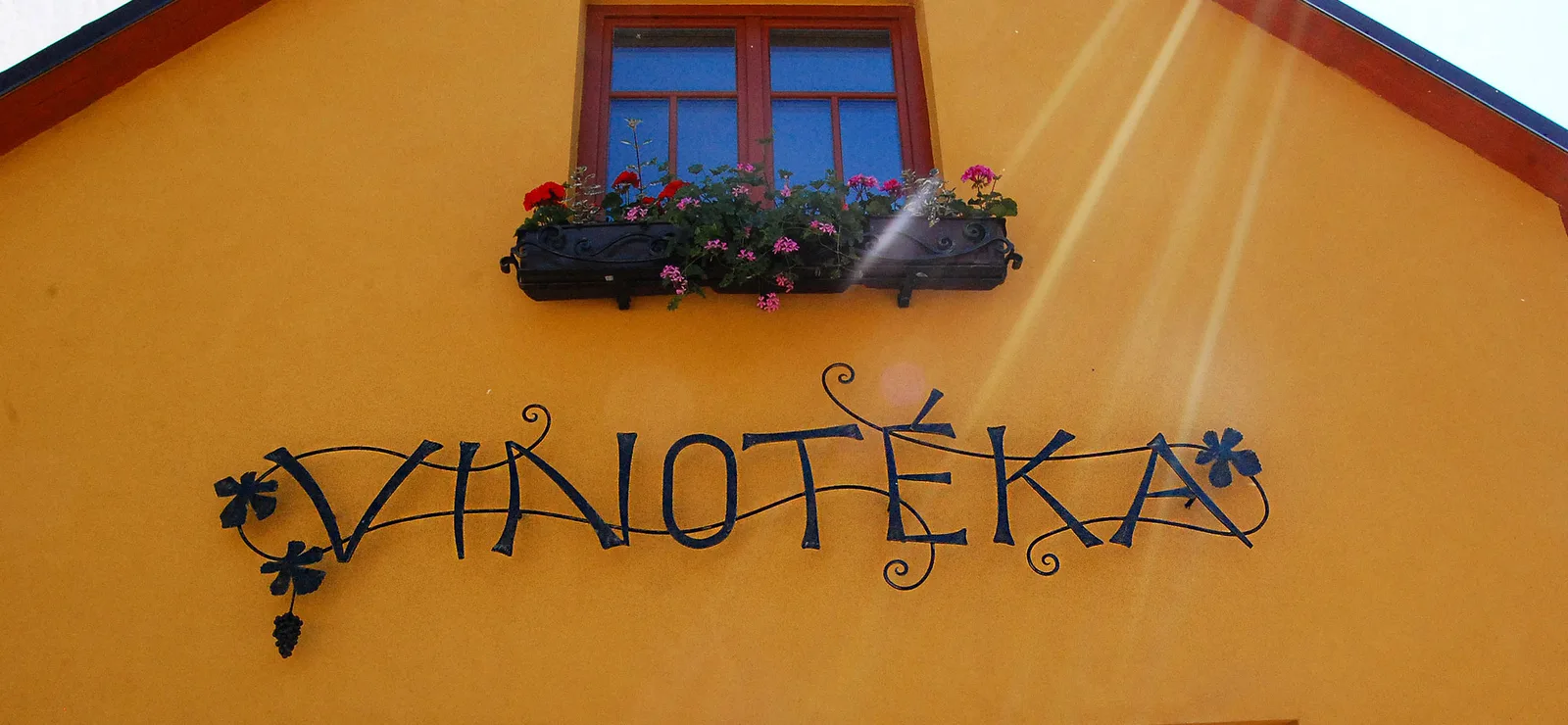 Fasáda vinotéky s kovanou cedulí VINOTÉKA